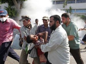 محتجون يحملون مصابا جراء اشتباكات أمام مقر الحرس الجمهوري في القاهرة
