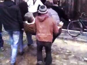 رجال يحملون جريحا في حمص
