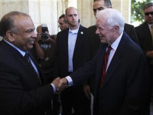 رئيس مجلس الشعب المصري سعد الكتاتني (الى اليسار) لدى استقباله للرئيس الأمريكي الأسبق جيمي كارتر في القاهرة يوم الاثنين