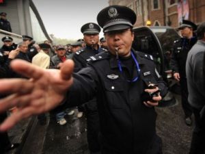 شرطي يطلب من مجموعة من الاشخاص الذين تجمعوا في شارع في شنغهاي الاحد 27 شباط/فبراير التفرق
