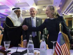 كلينتون تصافح وزير الخارجية الاماراتي ويتوسطهما وزير الخارحية البريطاني 