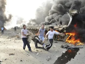اشخاص يحملون جثة محترقة بعد انفجار في دمشق 
