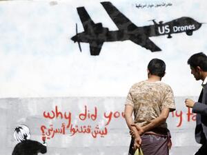 رجال ينظرون الى جدارية في صنعاء لطائرة اميركية بدون طيار 
