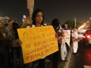 شابة تحمل لافتة ترفض اختبارات العذرية خلال تجمع في القاهرة