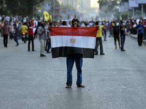 An Egyptian protestor holds his national flag during clashes between supporters of the Muslim Brotherhood and Egypt's ousted president Mohamed Morsi and security forces, in Cairo, on August 30, 2013. (AFP)