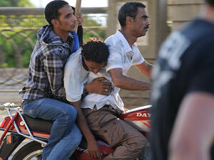 Army supporters evacuate an injured man after clashes with Morsi supporters on July 22. (AFP / FAYEZ NURELDINE)