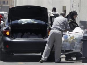 أسرة مصرية تضع مشترواتها من متجر للبقالة في الصندوق الخلفي للسيارة بالقاهرة
