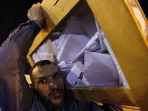 موظف في انتخابات مصر يحمل صندوق اقتراع تمهيدا للفرز
