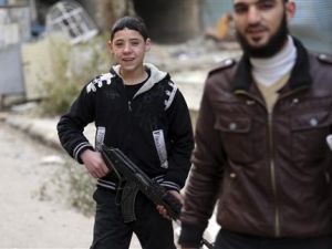 صبي من الجيش السوري الحر يحمل بندقية آلية في دمشق 
