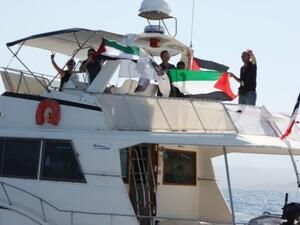 ناشطون يلوحون من على متن سفينة الكرامة عند ابحارها من كورسيكا السبت للانضمام الى اسطول الحرية المتوجه الى غزة 
