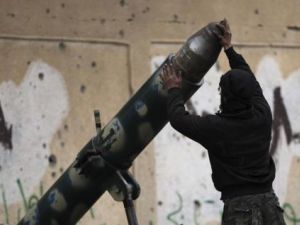 مقاتل من الجيش السوري الحر يجهز لاطلاق قذيفة مدفعية في دير الزور
