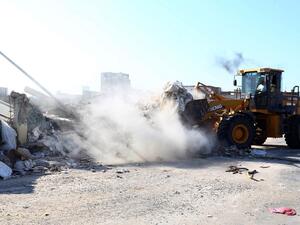 Workers tear into the wall of Moammar Gadhafi's compound in Tripoli on July 9, 2013. (source: AFP / MAHMUD TURKIA)