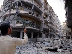 رجل يلتقط صورا بهاتفه النقال للدمار في حي طريق الباب في حلب بشمال سوريا

