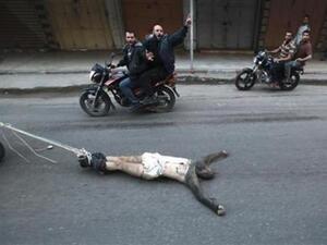 فلسطينيون على دراجة نارية يجرون على الأرض جثة أحد المشتبه في تعاونهم مع اسرائيل في شوارع غزة 

