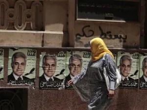 امرأة تمر بجوار ملصقات حمدين صباحي احد مرشحي الانتخابات الرئاسية المصرية