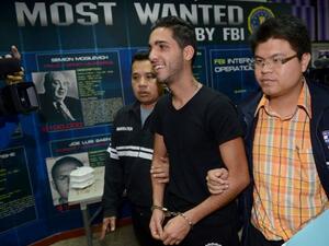 Algerian hacker Hamza Bendelladj is all smiles as he gets escorted towards a life behind bars. (photo courtesy of ArabCrunch )