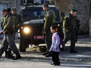 تلميذة فلسطينية تمر قرب شرطة حدود اسرائيليين في الخليل
