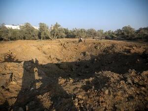 مدنيون فلسطينيون قرب حفرة تسببت بها غارة اسرائيلية في شمال قطاع غزة في 14 تشرين الثاني