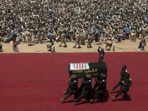 مسلحون يرتدون أزياء عسكرية شبيهة بالملابس التي ترتديها قوات الحرس الثوري الإيرانية بحملون رفات حسين الحوثي أثناء مراسم إعادة دفنه في صعدة باليمن
