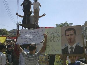 اشخاص يحتجون ضد الرئيس السوري بشار الاسد في حمص 
