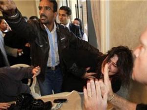 ايمان العبيدي داخل الفندق بينما يحاول موظفون ليبيون منعها من الحديث