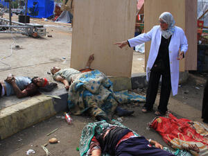 عدد من انصار مرسي ممددون على الارض بعد اصابتهم خلال فض قوات الامن لاعتصامهم في رابعة العدوية