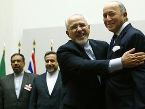 Iranian Foreign Minister Mohammad Javad Zarif hugs French Foreign Minister Laurent Fabius after a ceremony at the United Nations in Geneva on Nov. 24, 2013. 