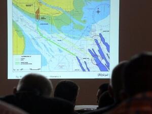 عراقيون ينظرون الى خريطة تظهر الاثر السلبي الذي يمكن ان يحدثه بناء ميناء مبارك على المرافئ العراقية
