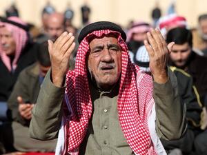 An Iraqi Muslim Sunni man prays during the weekly Friday noon prayers before an anti-government protest outside the Sunni Umm al-Qura mosque in Baghdad on Friday (Photo: AFP/AHMAD AL-RUBAYE)