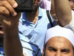 رجل يرفع مصحفا اثناء الاحتجاجات في التحرير
