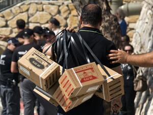 ISRAEL, Haifa : An Israeli man carries gas mask kits as he leaves a distribution center in the Mediterranean coastal city of Haifa, north of Israel, on August 29, 2013. AFP PHOTO / JACK GUEZ