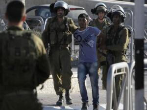 Israeli soldiers arrest a Palestinian youth in the West Bank's Qalandiya refugee camp on August 26, 2013. (AFP)