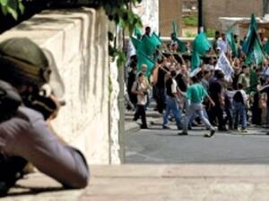 شرطي اسرائيلي يصوب بندقيته باتجاه متظاهرين من عرب 48 خلال احداث عام 2000