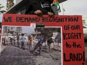 متظاهر يحمل لافتة تطالب بالاعتراف بحق الفلسطينيين في الارض