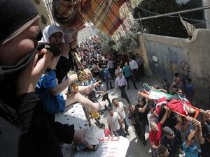 Palestinian mourners cry as other carry the body of Majd Lahluh, who was killed by Israeli soliders, during his funeral at Jenin refugee camp in the West Bank city of Jenin on August 20, 2013. (AFP)