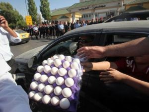 متظاهرون يوزعون البيض لرميه على مبنى البرلمان في عمان خلال التظاهرة الخميس
