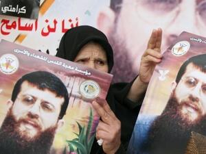 فلسطينية تحمل صورة لخضر عدنان