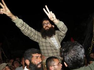 خضر عدنان يلوح بعلامة النصر عقب وصوله الى قريته قرب جنين في الضفة الغربية بعد اطلاق اسرائيل سراحه يوم 17 ابريل نيسان
