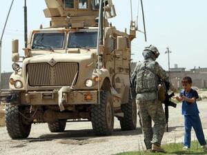 فتى عراقي يتكلم مع جندي اميركي يشارك في دورية في كركوك  