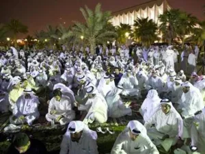 محتجون كويتيون يجلسون أمام مبنى البرلمان في العاصمة الكويت
