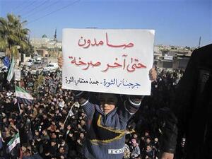 طفل يرفع لافتة ضد الرئيس السوري بشار الاسد بالقرب من ادلب