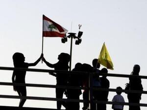 Hezbollah on Monday re-pledged its support to the Syrian regime and vowed to attack Israel. Lebanese children fly the national Lebanese flag (L) and the Hezbollah flag. (AFP/File)