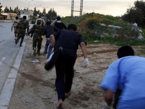 مقاتلون من الزاوية يحتمون خلال اشتباكات عند الخط الامامي لمدخل المدينة 
