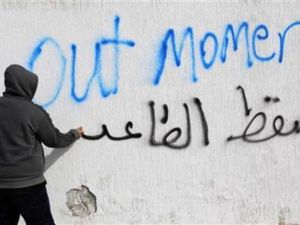 ليبي يكتب شعارات مناهضة للقذافي في طرابلس