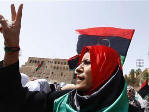 ليبية تشير بعلامة النصر أثناء أداء المصلين الصلاة في ميدان الشهداء بطرابلس
