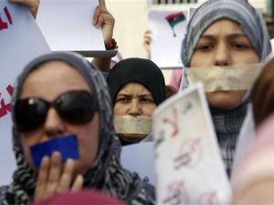 ليبيات يضعن لاصق على افواههن لدى مشاركتهن في مسيرة صامتة لدعم المرأة في طرابلس