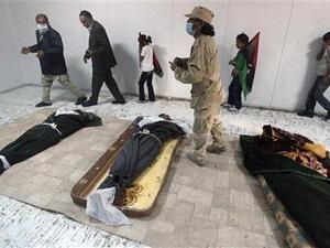 مواطنون ليبيون يلقون نظرة على جثامين معمر القذافي وابنه المعتصم بالله وقائد قواته ابو بكر يونس في مصراتة 
