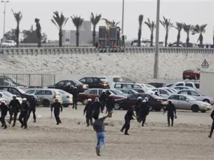 متظاهر ضد الحكومة يلقي حجارة على شرطة مكافحة الشغب اثناء محاولة المتظاهرين استعادة السيطرة على دوار الفاروق (اللؤلؤة سابقا) 
