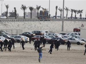 متظاهر ضد الحكومة يلقي حجارة على شرطة مكافحة الشغب اثناء محاولة المتظاهرين استعادة السيطرة على دوار الفاروق (اللؤلؤة سابقا) 
