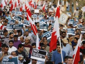محتجون مناهضون للحكومة يحملون اعلام البحرين ولافتات كتب عليها "لا للعنف الرسمي" خلال مسيرة غربي المنامة يوم الجمعة
